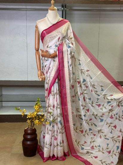 Picture of A white saree with a floral print and a pink border, draped on a mannequin